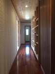 広く長い廊下は、和室を通り玄関部分に続いています。
壁には棚を設けました。